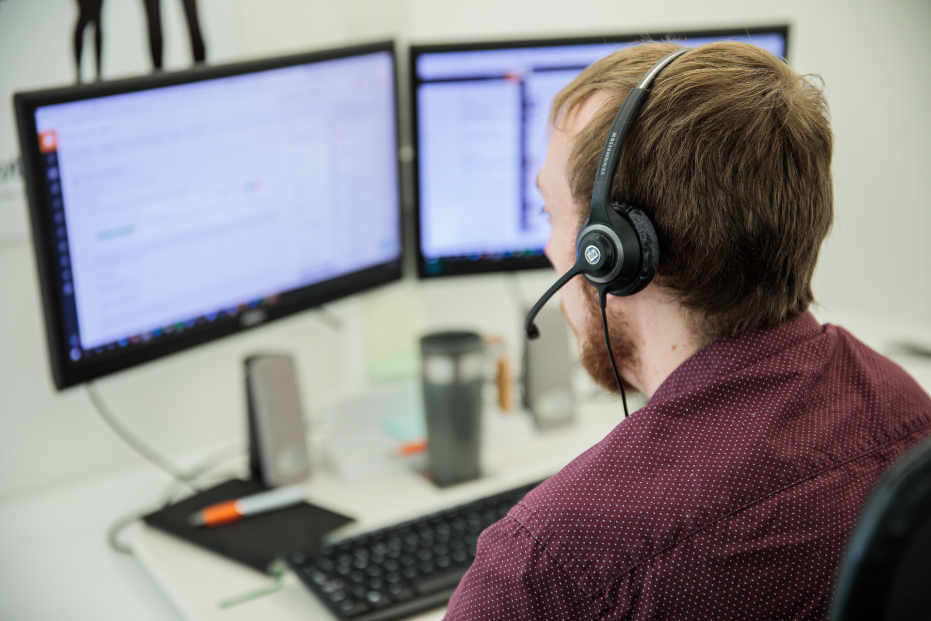A man wearing a headset working on his computer